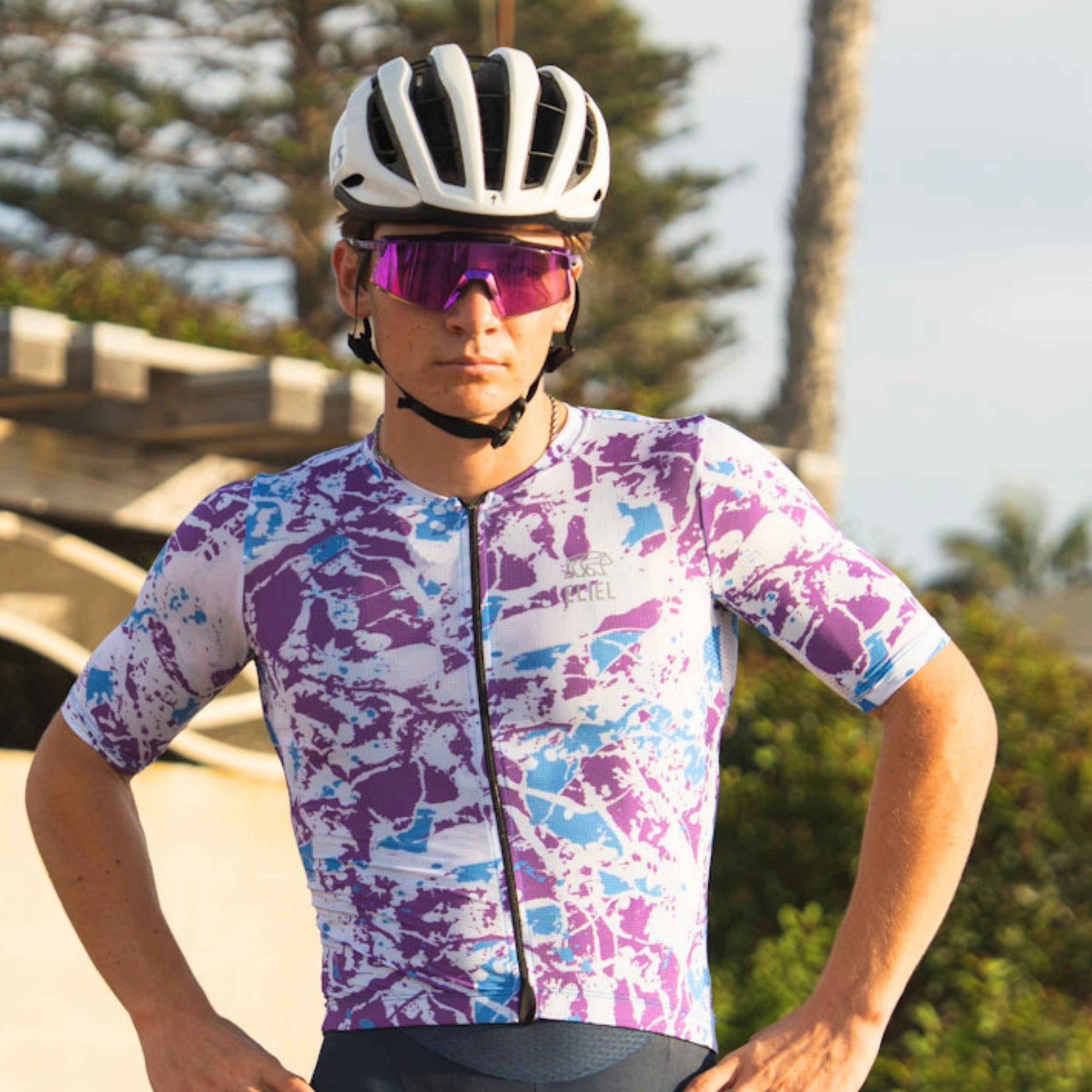 Male cyclist standing  in a multicolor jersey