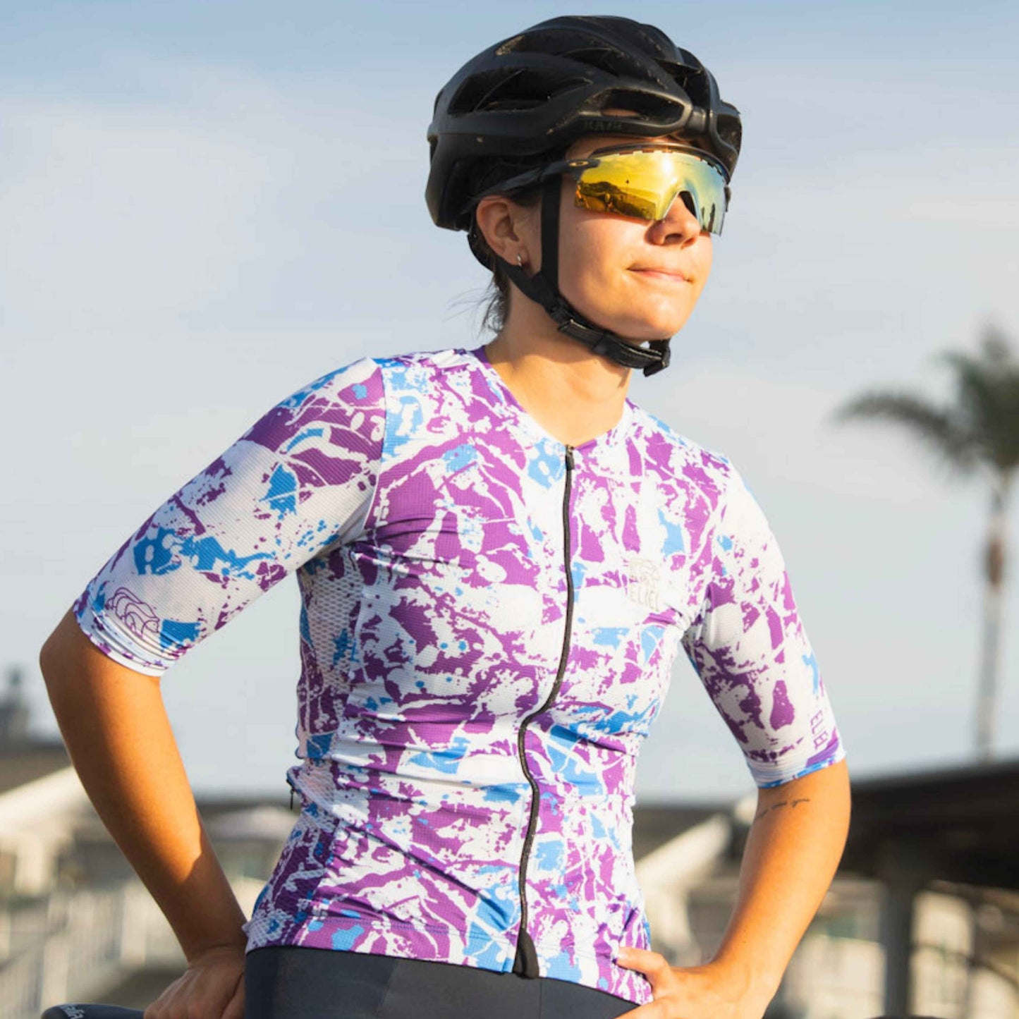 Female cyclist standing in purple and blue jersey
